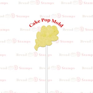 May include: A yellow cake pop mold shaped like an oak leaf. The mold is on a white stick and is ready to be used to make cake pops.