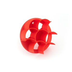 May include: A red plastic geometric object with a circular base and multiple curved compartments. The object is designed to hold small items.