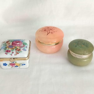 Puede incluir: Tres cajas decorativas, una con un diseño floral, otra con un diseño floral rosa y otra con un diseño floral verde.