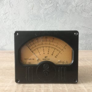 Puede incluir: Un medidor analógico negro con una cara redonda y una aguja. La cara está etiquetada con números del 0 al 50 y tiene una escala marcada en ohmios. El medidor está etiquetado con "ГОСТ 1845-59 3-68 г." y "ит СДЕЛАНО В СССР".