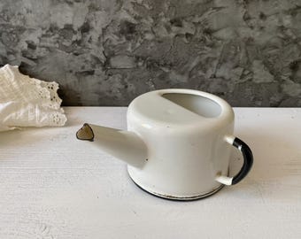 White enamel mug with spout and handle.