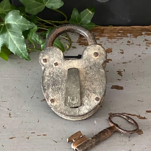Old padlock with key, early 20th century padlock, vintage metal lock