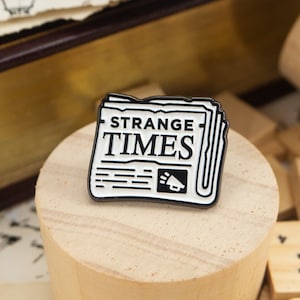 Strange Times Chronicle Enamel Pin – Newspaper print | Minimalist Pins | Monochrome Design | Black and White Pins