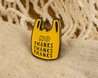 May include: Yellow plastic bag pin with black outline and the text "NO THANKS THANKS THANKS THANKS" on it.