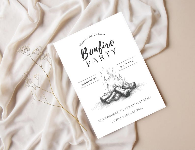 May include: A white invitation card with the text "Bonfire Party" in a script font, featuring a bonfire illustration. The card includes event details like the date, time, and RSVP information. The background is a beige surface with a white fabric.