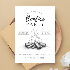 May include: A white invitation card with the text "Bonfire PARTY" and a detailed illustration of a bonfire. The card includes the date, time, and RSVP information. The invitation is placed on a wooden plate with a brown envelope.