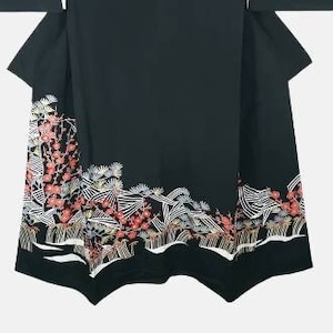 May include: A black kimono with a white and red floral pattern on the bottom hem. The kimono has long sleeves and a wide collar.