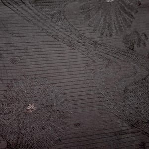 May include: Black fabric with an embossed floral pattern. The fabric has a subtle sheen and a textured surface.