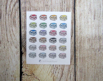 May include: A sheet of colorful book stack stickers. The stickers are in various colors, including red, orange, yellow, green, blue, purple, brown, pink, and gray. Each sticker features a stack of three books with white pages.