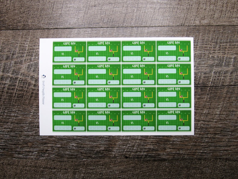 May include: A sheet of 16 printable football game day labels. Each label features a green field with a football goal post and a football. The text "GAME DAY" is at the top of each label with the word "VS" below it.