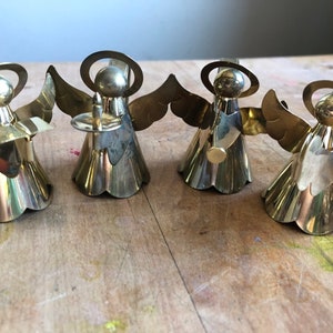 May include: Set of four gold angel napkin rings. Each angel is holding a different musical instrument.