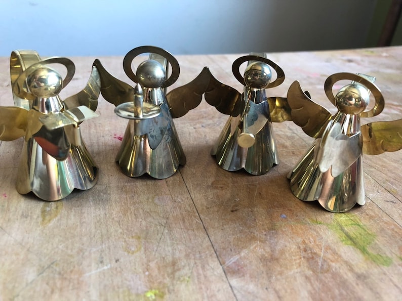 May include: Set of four gold angel napkin rings. Each angel is holding a different musical instrument.