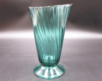 May include: A teal blue glass vase with a twisted design and a flared base.