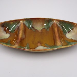 May include: A brown, green and white ceramic serving dish with three divided sections. The dish has a glossy finish and a unique, swirled pattern.