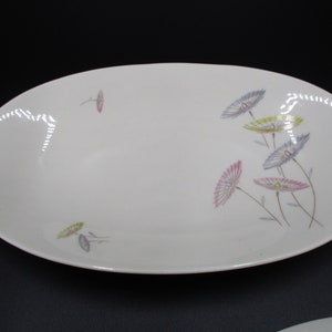 May include: White oval serving dish with a floral design. The flowers are pink, blue, and yellow with green stems.
