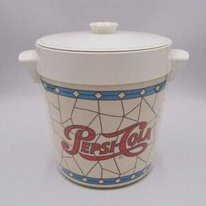May include: White plastic ice bucket with a blue and white stained glass design and the Pepsi-Cola logo in red and white.