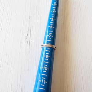 May include: A blue ring sizer with white markings, showing a ring size of 7.