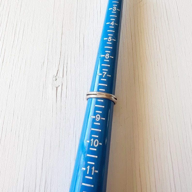 May include: A blue ring sizer with white markings, showing a ring size of 7.