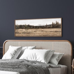 May include: A rectangular framed landscape painting depicting a field with trees and a figure. The artwork features a muted color palette of browns, greens, and grays, creating a serene and naturalistic scene. The frame is a warm brown.