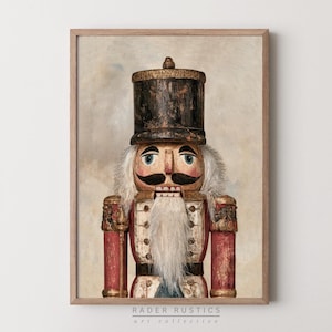 May include: A framed wall art print featuring a weathered nutcracker with a dark cylindrical hat, a long white beard, and a red uniform with gold accents. The nutcracker has painted blue eyes and a black mustache. Text at the bottom reads Rader Rustics.