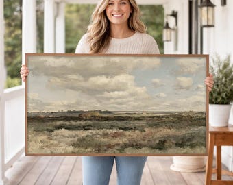 May include: A framed landscape painting depicting a cloudy sky over a field of grass and brush. The artwork is in a wooden frame and features muted tones of green, brown, and blue. The painting evokes a sense of peace and natural beauty.
