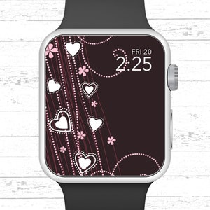 Pode incluir: Um smartwatch preto e prata com um design de corações rosa e branco na tela. O horário é 2:25 e a data é FRI 20.