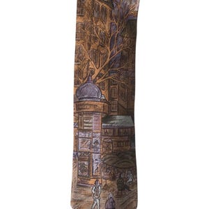 May include: A necktie featuring a detailed illustration of a Parisian street scene in shades of brown, tan, and muted purple. The print depicts multi-story buildings, a bare tree, a street kiosk, and figures walking or sitting at outdoor cafe tables.