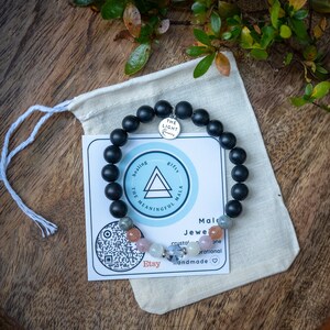 May include: Black beaded bracelet with a silver charm that says "The Light Within". The bracelet is on a white fabric pouch with a card that says "Healing, The Meaningful Mala, Gifts" and "Mala Jewelry, Crystal, One Rational, Handmade".