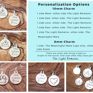 May include: A set of silver charm pendants with different designs, including a paw print, a heart, a triangle with the words "The Meaningful Mala", and a circle with the words "The Light Remains".