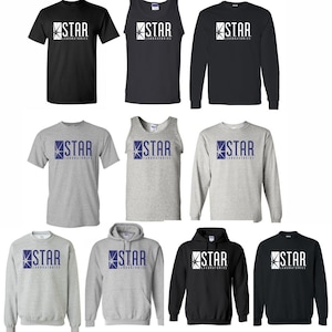 May include: A collection of black and gray apparel featuring the "STAR LABORATORIES" logo in white and blue. The items include t-shirts, tank tops, long-sleeve shirts, sweatshirts, and a hoodie.