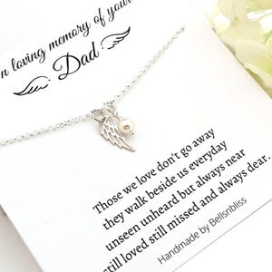 May include: A silver necklace with a pendant featuring a pearl and a wing design. The necklace is displayed on a white card with the text "In loving memory of your Dad" and a poem about loved ones.
