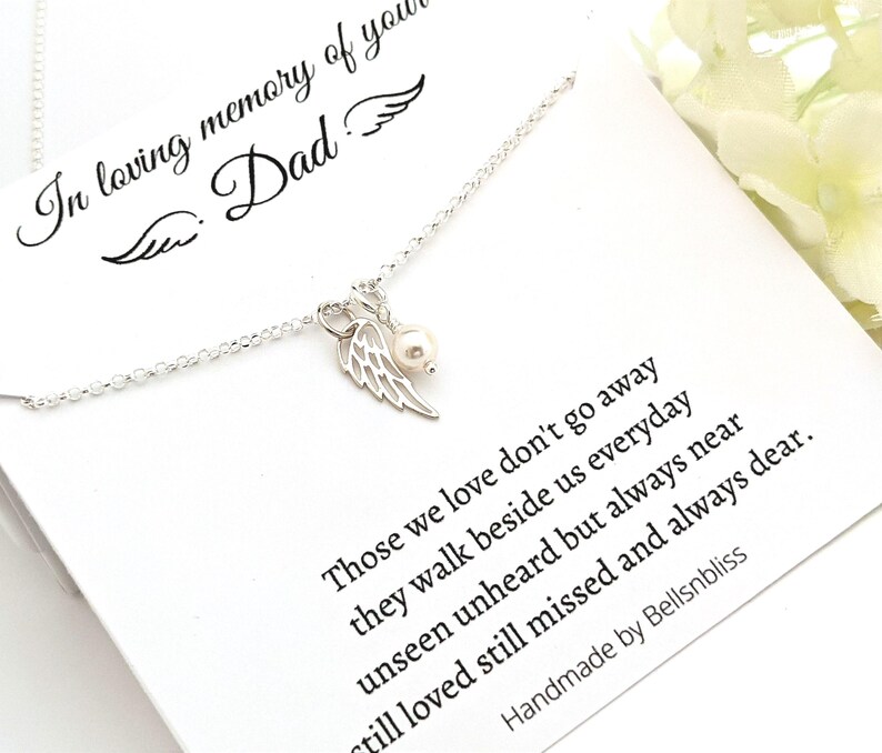 May include: A silver necklace with a pendant featuring a pearl and a wing design. The necklace is displayed on a white card with the text "In loving memory of your Dad" and a poem about loved ones.