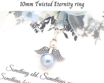 May include: A silver angel charm with a light blue pearl body and pearl head, detailed wings, and a silver loop. The charm is attached to a light blue ribbon with floral accents. Text reads "Something old. Something new."