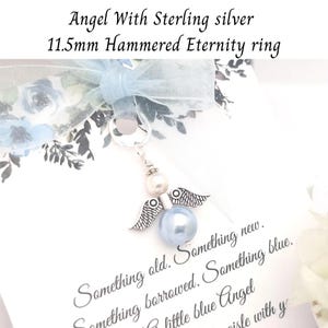 May include: A sterling silver angel charm with a blue pearl body and silver wings. The charm is attached to a ring and is accompanied by a light blue ribbon and text that reads "Something old. Something new. Something borrowed. Something blue."