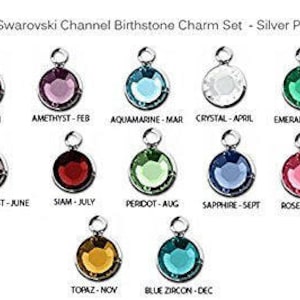 Op de afbeelding: Zilver vergulde Swarovski geboortesteen bedels. Elke bedel heeft een ronde, gekleurde kristal in een zilveren kanaalzetting. De bedels zijn gelabeld met geboortesteennamen en maanden: Siam (januari), Amethist (februari), Aquamarijn (maart), Kristal (april), etc.