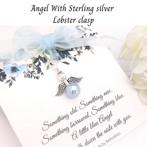 May include: A small angel charm with a sterling silver lobster clasp. The angel features a light blue bead, a white pearl, and silver wings. The charm is attached to a card with text that reads "Something old. Something new. Something borrowed. Something blue."