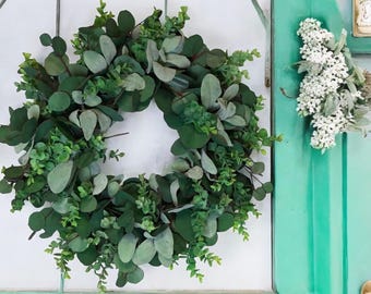 Könnte beinhalten: Ein grüner Eukalyptus-Kranz vor weißem Hintergrund. Der Kranz besteht aus künstlichen Blättern und Zweigen.