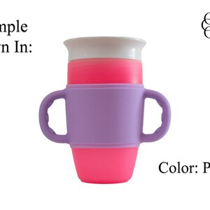 May include: Purple silicone cup holder with two handles. The cup holder is designed to fit around a standard-sized cup. The cup holder is shown with a pink cup inside.