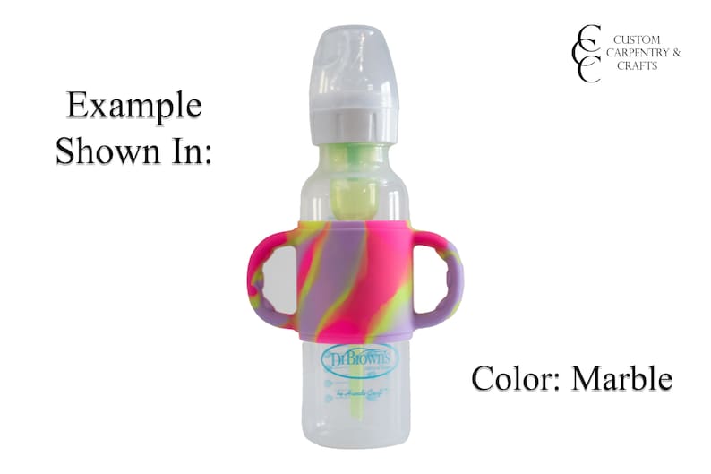 May include: A clear baby bottle with a silicone handle in a marble pattern of pink, purple, and yellow. The bottle has a Dr. Brown's label.