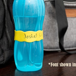 May include: A blue water bottle with a yellow label that says "Josiah Sr." in a decorative font.