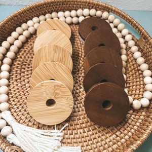 May include: A woven basket tray with a white tassel, a string of wooden beads, and two sets of wooden rings. One set is light brown and the other is dark brown.
