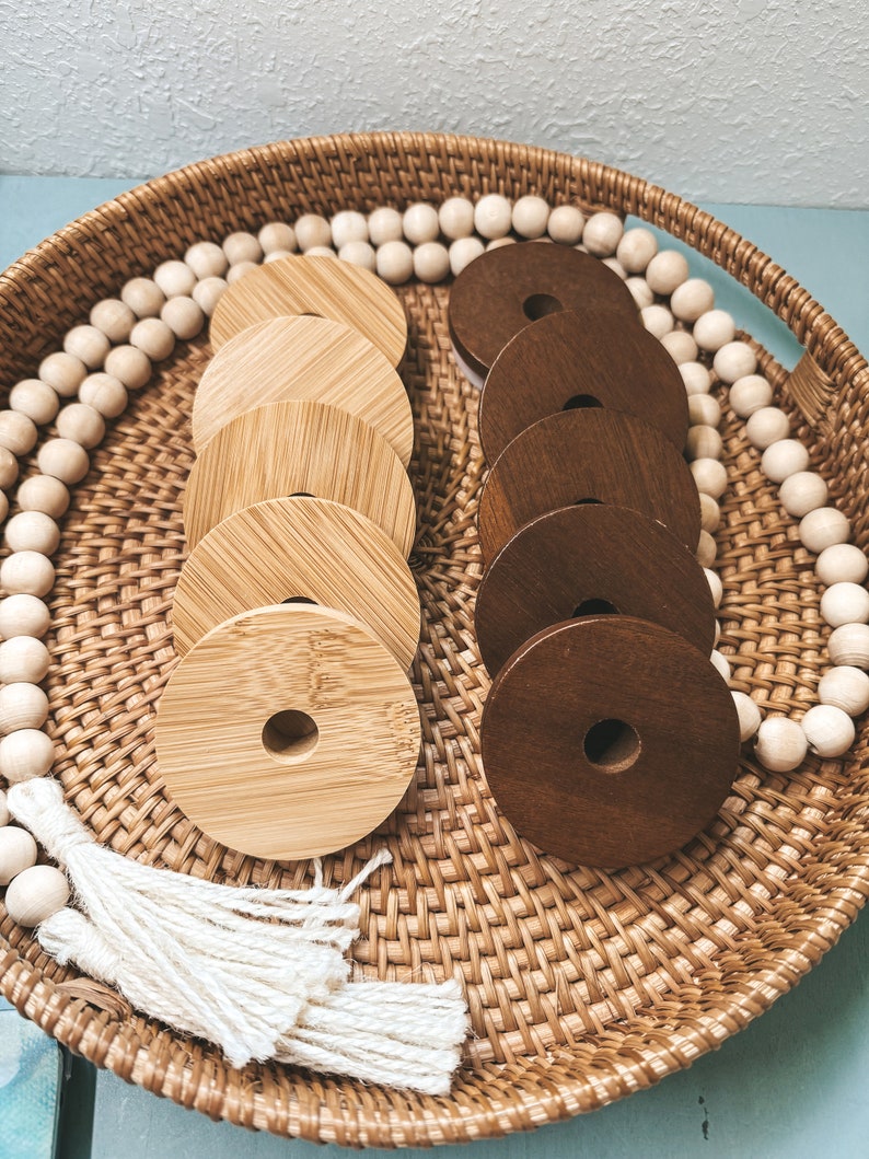May include: A woven basket tray with a white tassel, a string of wooden beads, and two sets of wooden rings. One set is light brown and the other is dark brown.