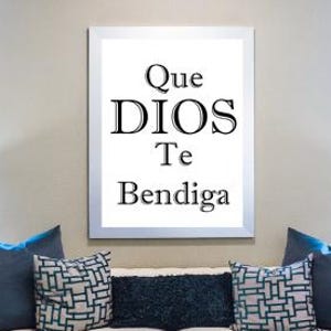May include: A living room scene featuring a white sofa with blue pillows and decorative vases. A framed print on the wall displays the text "Que DIOS Te Bendiga". Two lamps flank the sofa, and the room has a neutral color palette.