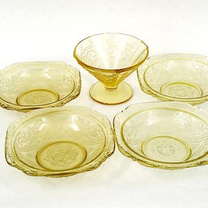 May include: Set of five yellow glass bowls with a delicate floral pattern. The bowls are square with rounded edges and have a vintage look.