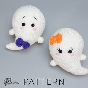Könnte beinhalten: Zwei gehäkelte Geister-Amigurumi-Spielzeuge. Ein Geist hat eine violette Schleife und der andere eine orange Schleife. Beide Geister haben schwarze Augen und rosa Wangen.