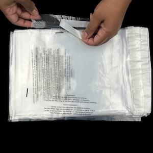 May include: A stack of clear plastic mailing bags with a warning label printed on the front. The label reads: "WARNING Keep this bag away from babies and children. Do not use in cribs, beds, carriages, or playpens. The thin film may cling to the nose and mouth and prevent breathing."