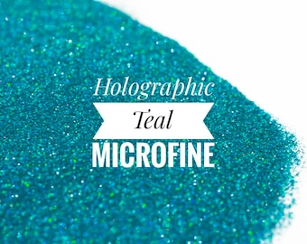 May include: A close-up of teal holographic microfine glitter. The glitter is very fine and has a iridescent sheen.