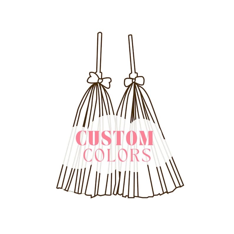 May include: Two white tulle fabric bows with black ribbon ties and the text "CUSTOM COLORS" in pink letters.