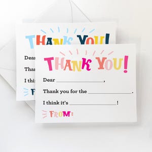 May include: A set of two blank thank you cards with colorful text that reads "Thank You!" The cards have lines for writing a message and a space for the sender's name.