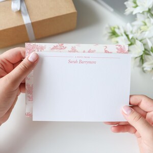 May include: A white note card with a pink floral border and the text "A note from Sarah Barrymore" printed on the top.